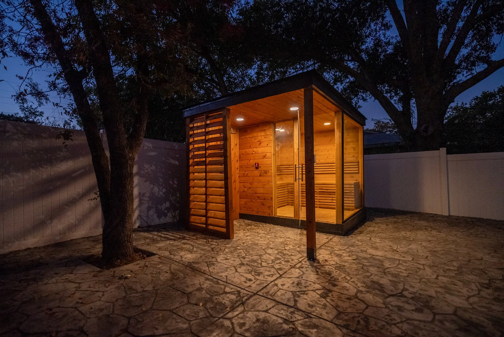 Custom outdoor sauna illuminated at night