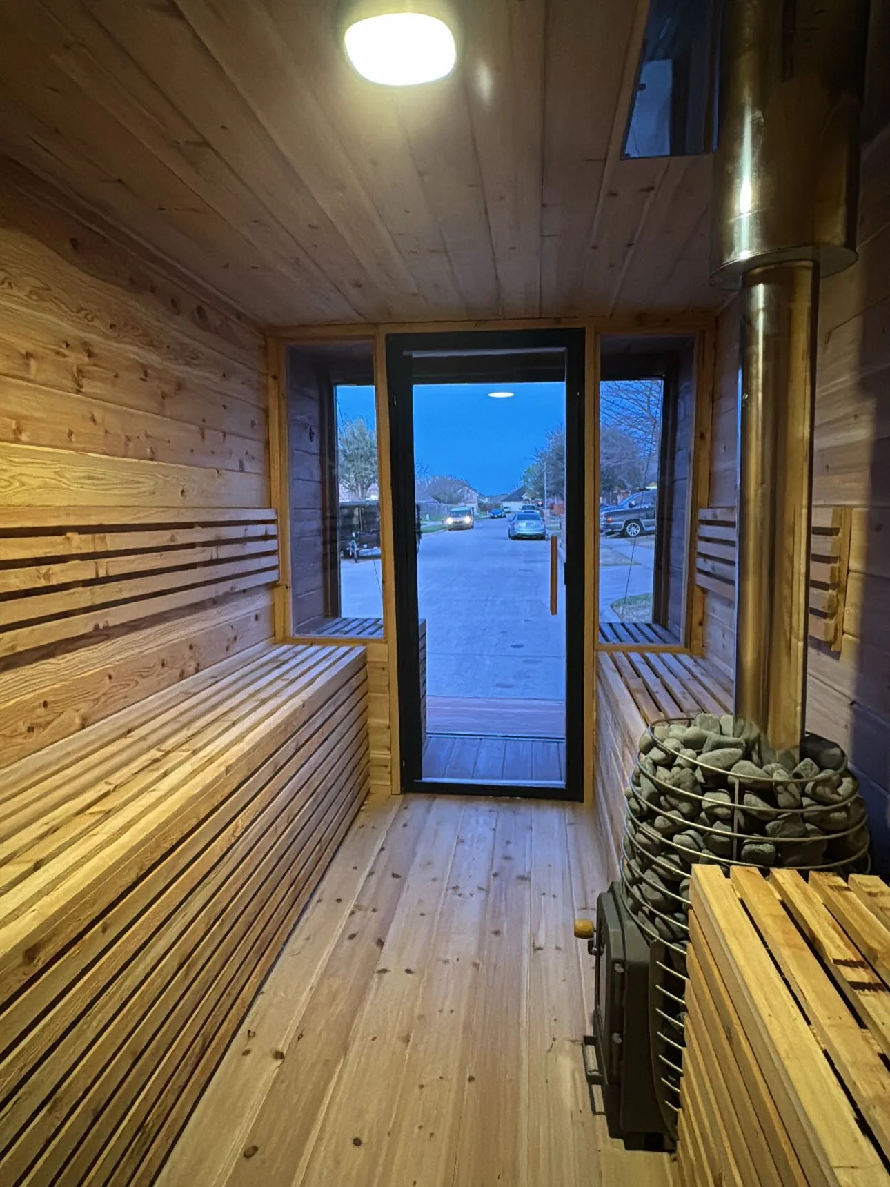 Wide view of portable sauna interior with cedar benches